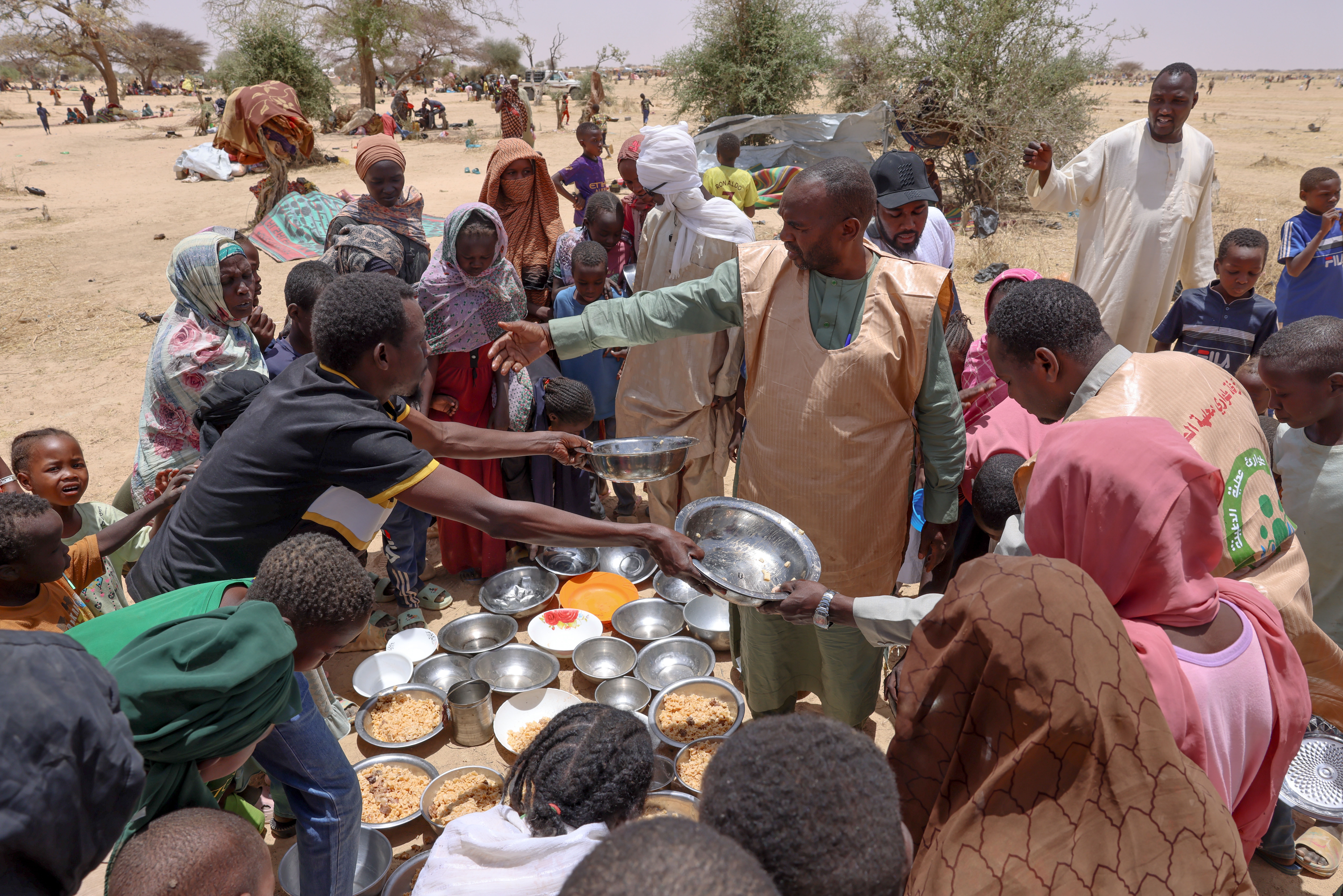 Volunteers from the Sudan Emergency Response Rooms hand out food to families displaced by the country